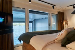 Schlafzimmer mit einem Bett und Blick auf das Wasser in der Unterkunft Nomad Water Studio in Harderwijk