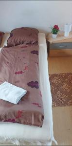 a bed with a brown blanket on top of it at Kéktúrás-Tóra Nyíló privát bérlemény in Badacsonytomaj