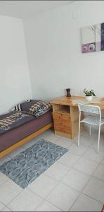 a bedroom with a bed and a desk and a chair at Kéktúrás-Tóra Nyíló privát bérlemény in Badacsonytomaj