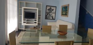sala de estar con mesa de cristal y TV en Casa Mar e Lua, en Natal