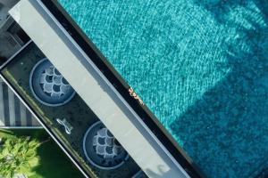 an overhead view of a swimming pool with blue water at Oceanfront Beach Resort - SHA Extra Plus in Patong Beach