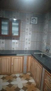 eine Küche mit Spüle und Fliesenboden in der Unterkunft Shanti Jungle cottage in Mashobra + 54 Fotos