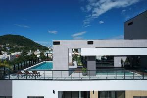 a view of a house with a swimming pool at Adra 205 - Apartamento no centro de Bombinhas - Rooftop com piscina e academia - À poucos metros da praia - (Consultar serviços de roupas de cama e banho) in Bombinhas