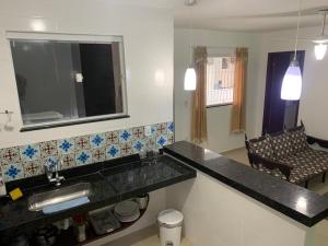 a bathroom with a sink and a counter with a mirror at Aloha Beach Temporada in Cabo Frio