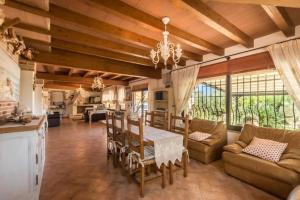 a kitchen and living room with a table and chairs at villa con immenso giardino in Orosei