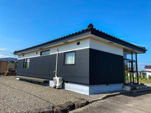 a small house with a black and white at Port Front ポートフロント 釣りに最適 in Shikyū