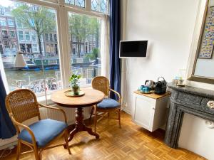 une chambre avec une table, des chaises et une fenêtre dans l'établissement Canal Hideaway, à Amsterdam