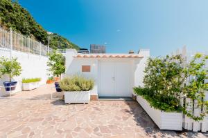 a white building with a door and some plants at La Vecchia Portineria in Cetara