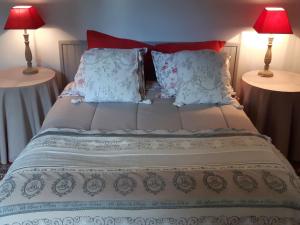 uma cama grande com dois candeeiros em duas mesas em Chambres d'Hôtes Domaine du Bois-Basset em Saint-Onen-la-Chapelle