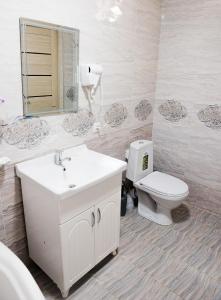 W łazience znajduje się toaleta, umywalka i lustro. w obiekcie Durdona Guest House w Samarkandzie