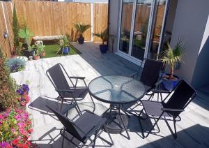 a patio with a table and chairs and a fence at Sam's retreat in Hayle +6 photos
