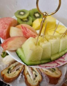 un plato de comida con un montón de fruta y sándwiches en Chaehyodang Hanok Stay en Seúl