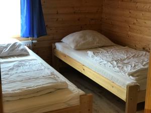 2 Einzelbetten in einem Zimmer mit Holzwänden in der Unterkunft Domki Prestige in Ustronie Morskie