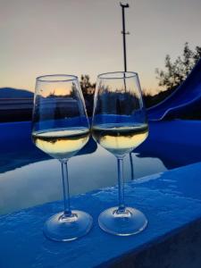 two glasses of white wine sitting on a table at Idiličan brijeg in Višegrad