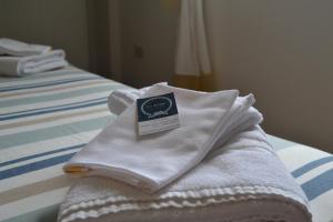 een stapel handdoeken bovenop een bed bij CA' de GINO in Santo Stefano al Mare