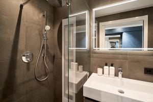 a bathroom with a shower and a sink and a mirror at Captains Boathouse Studio in Harderwijk