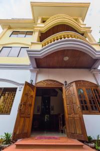 uma entrada para uma casa com portas de madeira em Happy Heng Heang Guesthouse em Siem Reap