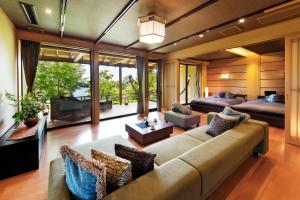 a large living room with a couch and a tv at Noto Hyakurakusou in Ogi