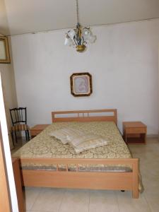 1 dormitorio con cama y lámpara de araña en Casa Vacanze "Za N'Zina", en Dattilo