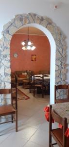una sala da pranzo con parete in pietra, tavolo e sedie di Casa Vacanze "Za N'Zina" a Dattilo