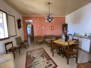 sala de estar con mesa de comedor y sillas en Casa Vacanze "Za N'Zina", en Dattilo