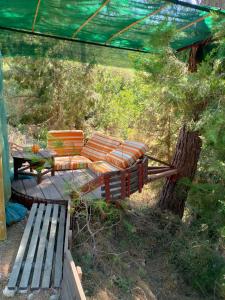 a patio with a couch and a table and a bench at VinSan Glamping & Wellness Centre in Eleoúsa