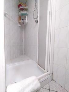 bagno con doccia e asciugamano sul pavimento di GRAYNITE-Old Village Apartment a Ponte di Legno