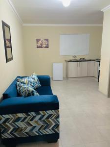 Druza’s guest house في روستنبرج: غرفة معيشة مع أريكة زرقاء أمام شاشة