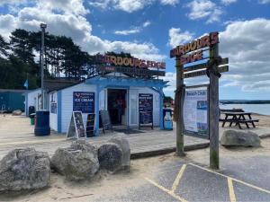eine Fischhütte am Strand mit Felsen davor in der Unterkunft Cosy, coastal themed Holiday Home, Rockley Park, Poole, Dorset in Poole
