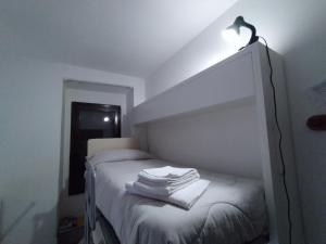 una camera da letto con un letto con una luce sopra di GRAYNITE-Old Village Apartment a Ponte di Legno