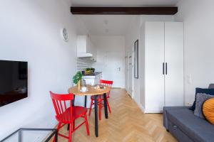 a living room with a table and red chairs at Wspólna 54A - Red - Good Apartments in Warsaw
