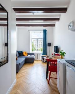 een woonkamer met een bank en een tafel bij Wspólna 54A - Red - Good Apartments in Warschau