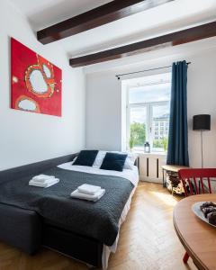 een slaapkamer met een groot bed en een raam bij Wspólna 54A - Red - Good Apartments in Warschau