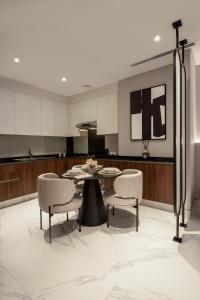 Lusso Hometels J One Business Bay في دبي: غرفة طعام مع طاولة وكراسي