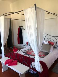 a bedroom with a canopy bed with red and white curtains at Maison des Ingénieurs in Molières-sur-Cèze