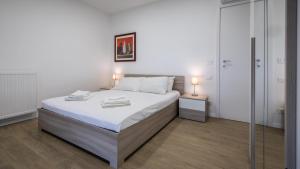 a bedroom with a bed with white sheets and two lamps at Italianway - Vat 52 in Udine
