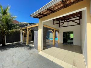 Cette maison dispose d'une terrasse avec un palmier. dans l'établissement Casa com piscina Balneario Ipanema PR, à Pontal do Paraná