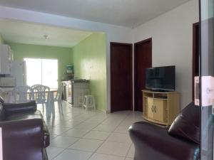- un salon avec un canapé et une télévision dans l'établissement Casa com piscina Balneario Ipanema PR, à Pontal do Paraná