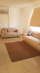 a living room with two beds and a rug at Andris apartment in Paralimni +18 photos