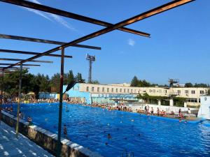 a large swimming pool with people in the water at Hostel Golden Fleece in Kutaisi