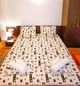 a bed with a black and white comforter and pillows at Forest Sunrise in Samokov
