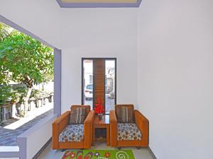 um quarto com duas cadeiras e uma mesa num alpendre em OYO 91192 Homestay Antara em Gilimanuk