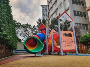 un parque infantil con un tobogán frente a un edificio en SweetSuites at Pine Crest #T3-1212 en Manila