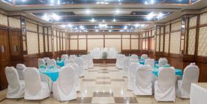 un salón de banquetes con sillas blancas y mesas. en Hotel Kalinga Ashok, en Bhubaneshwar