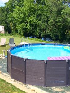 a large swimming pool with a wooden fence around it at Domaine de Seugnac in Pons