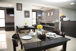 a dining room with a black table and chairs at Nobile Inn Executive Ribeirao Preto in Ribeirão Preto
