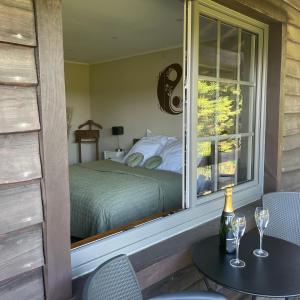 1 dormitorio con 1 cama y ventana con mesa y sillas en Le Sommelet en Somme-Leuze