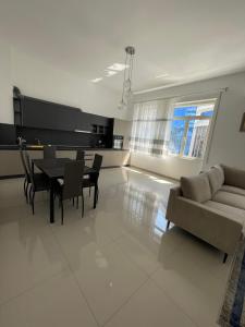 sala de estar con sofá, mesa y sillas en Westwood 2Bd Apartments en Durrës
