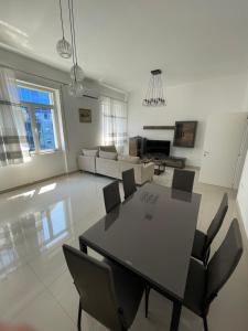 sala de estar amplia con mesa y sillas en Westwood 2Bd Apartments en Durrës
