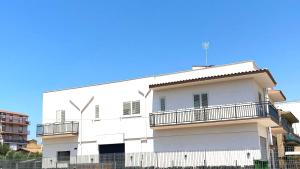 Biały budynek z płotem przed nim w obiekcie B&B Ercole Agrigento w mieście Villaggio Mosè